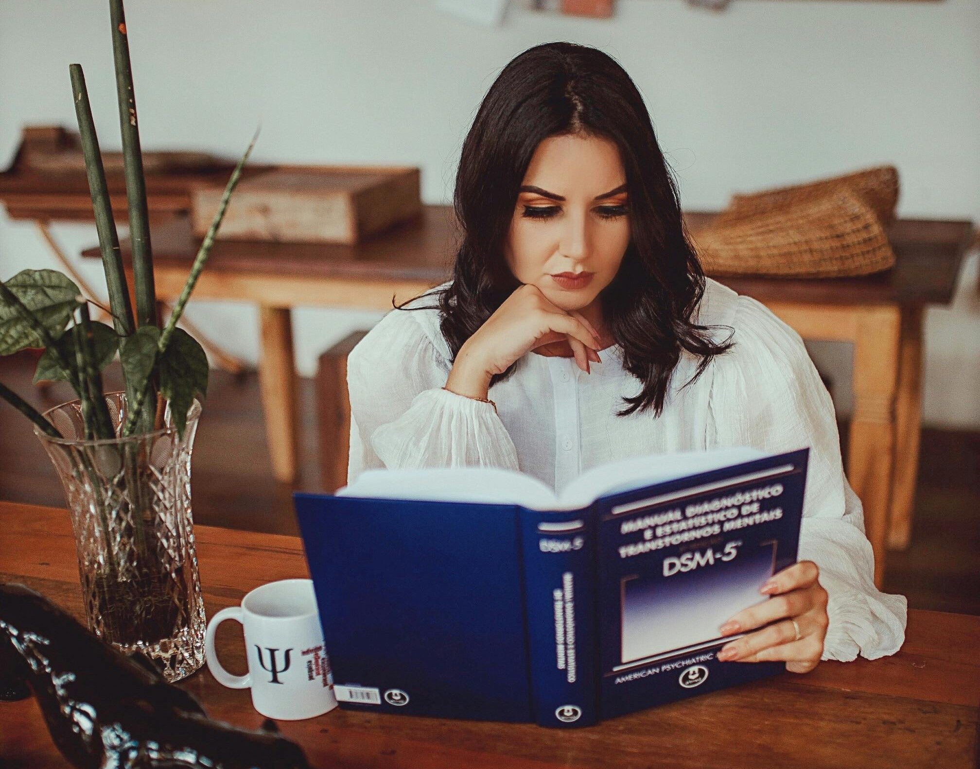 A woman reads the Diagnostic Statistical Manual for Mental Disorders.